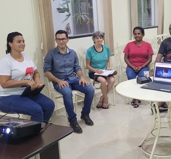 Grupo de pessoas reunidas em uma sala de reunião, discutindo pautas e diretrizes para os sindicalizados.